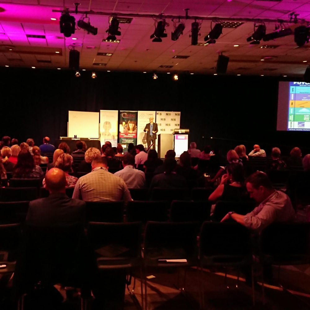 Speaker presenting to a seated conference audience